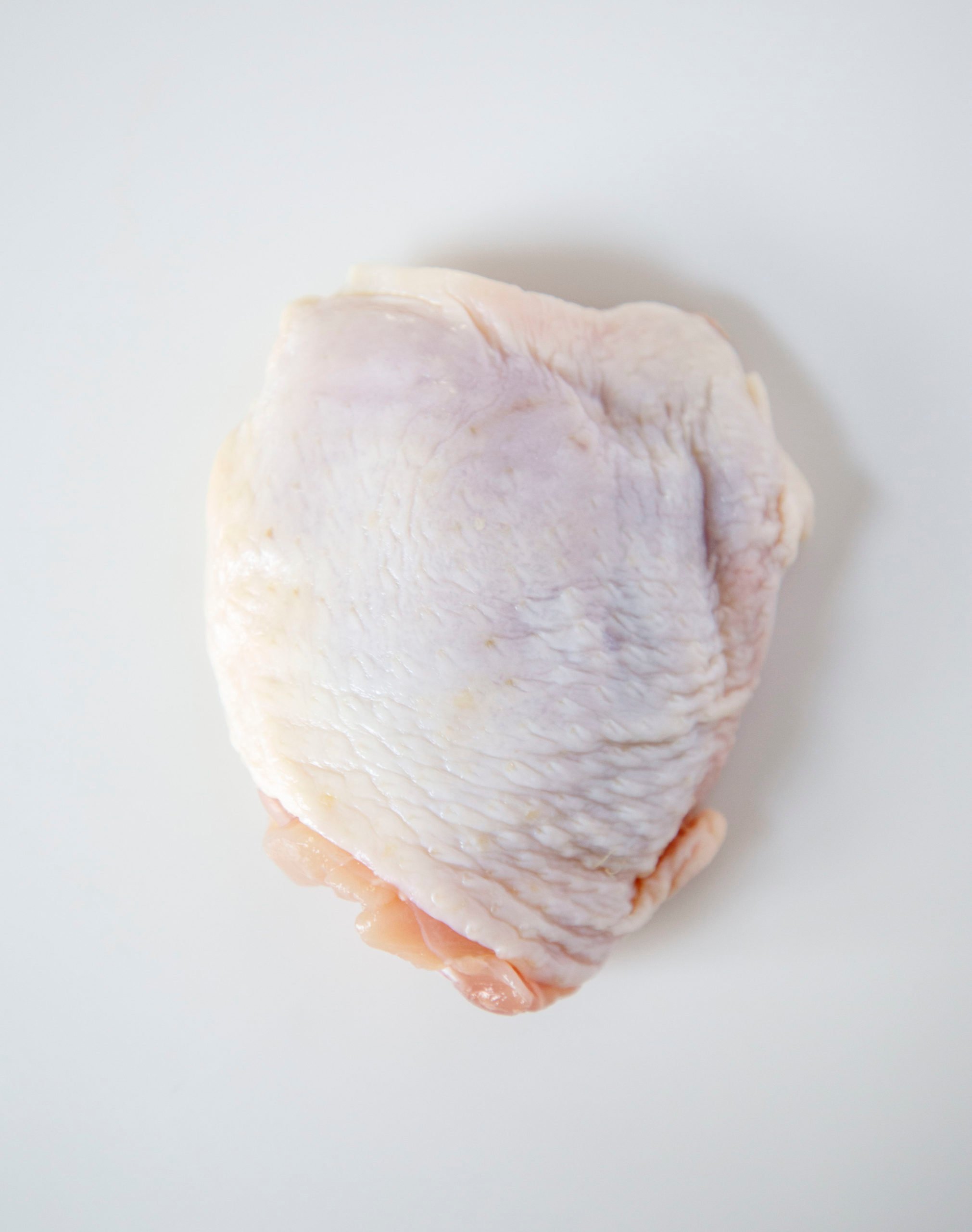 raw chicken thigh on a white background