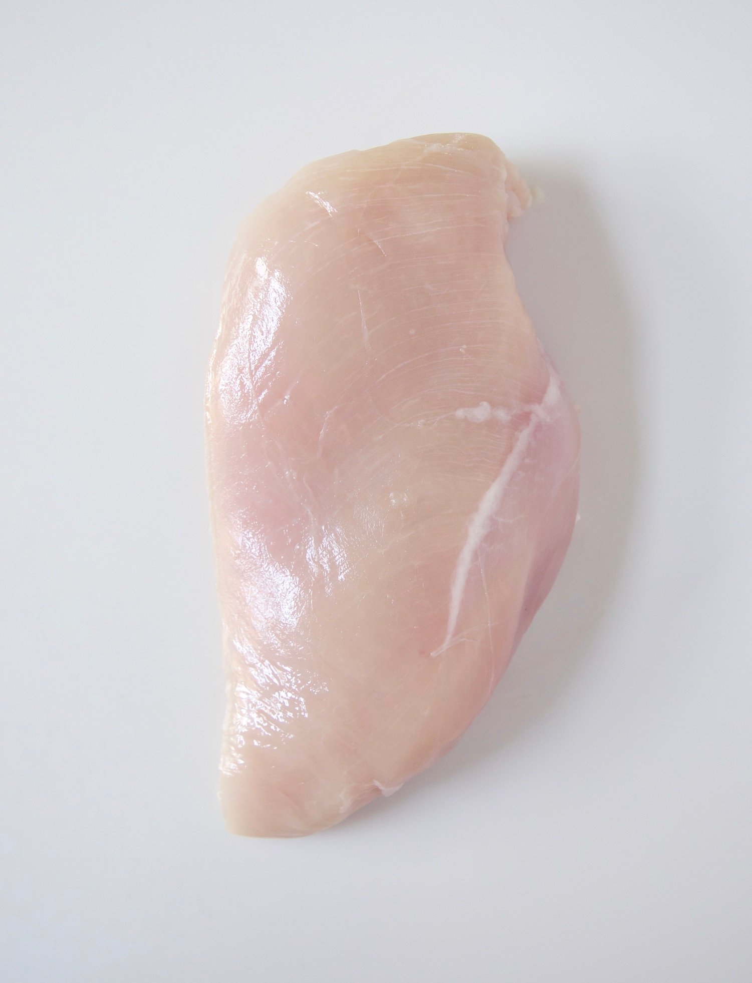 raw boneless, skinless chicken breast on a white background